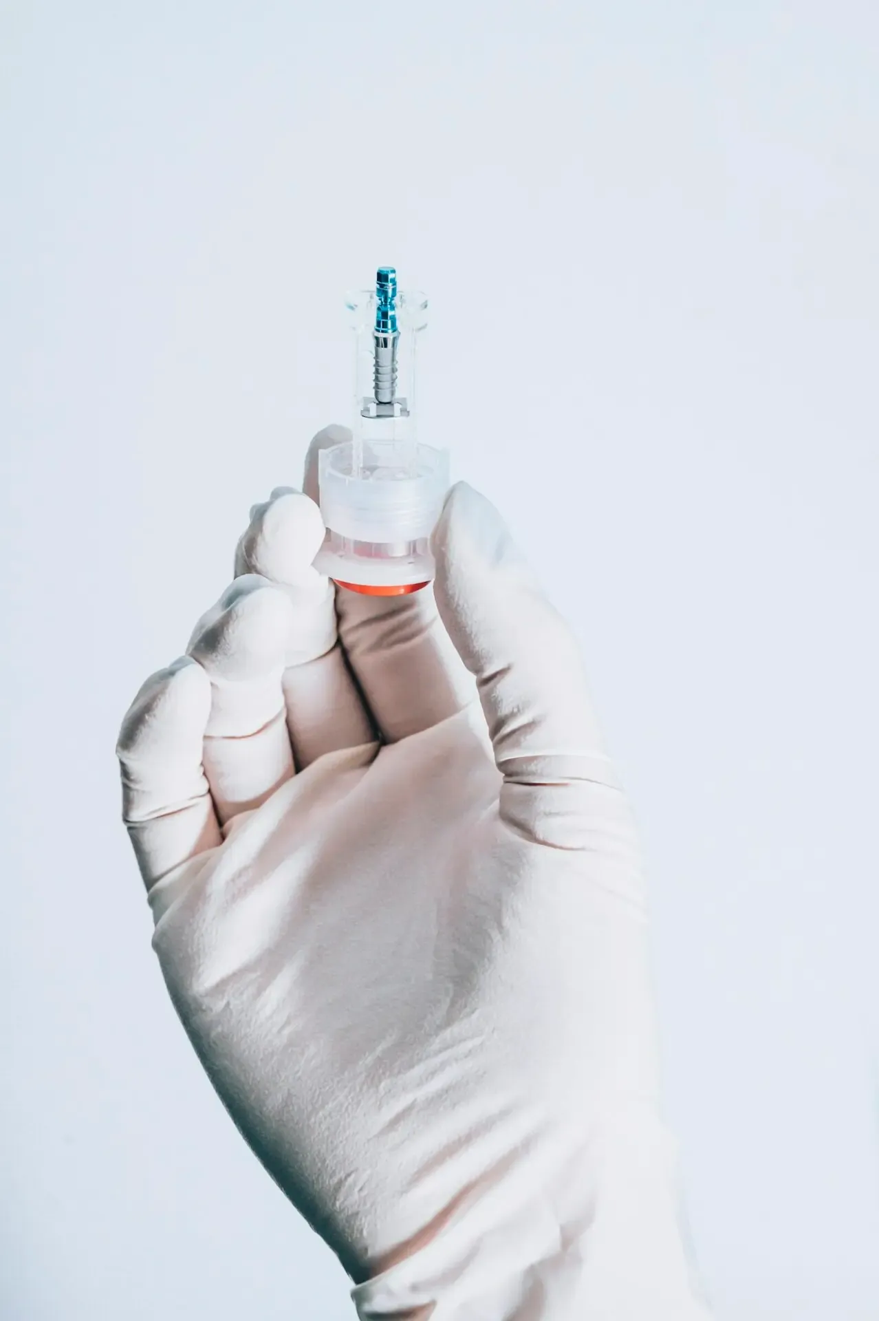 A hand holding a dental implant model